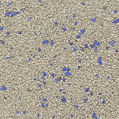 Close-up of cat litter with grey granules and blue particles.