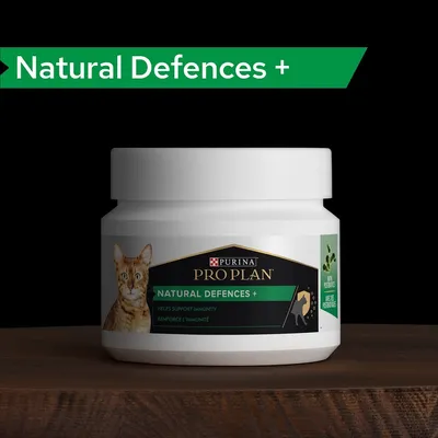 Bote de suplemento para gatos Purina Pro Plan Natural Defences+, texto visible: 'Helps support immunity', 'Renforce l'immunité', con imagen de un gato y símbolo de ingredientes vegetales.