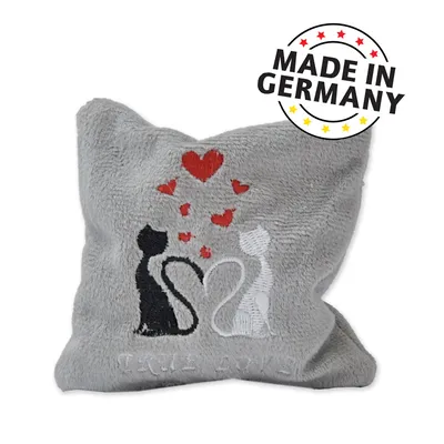 Coussin gris en tissu avec broderie de deux chats, un noir et un blanc, entourés de cœurs rouges. Texte visible : MADE IN GERMANY. Coussin gris en tissu avec broderie de deux chats, un noir et un blanc, entourés de cœurs rouges. Texte visible : MADE IN GERMANY.