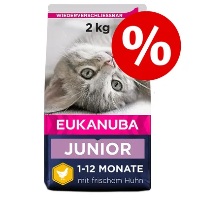 Pachet Eukanuba Junior 2 kg, imagine cu pisică, text vizibil: 1-12 Monate, mit frischem Huhn, simbol reducere procentuală pe fundal roșu.