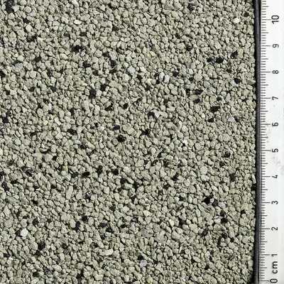 Close-up of grey, granular particles with a centimetre scale on the right side for size reference. Close-up of grey, granular particles with a centimetre scale on the right side for size reference.