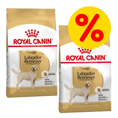 Due confezioni di crocchette Royal Canin Adult Labrador Retriever con simbolo percentuale giallo per offerta. Testo visibile: 'Over 15 months old'. Immagine di un Labrador su ogni confezione.