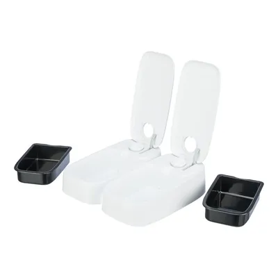 Due distributori automatici bianchi con coperchio aperto e due vaschette nere separate, ciascuna suddivisa in scomparti. Materiale plastica visibile. Due distributori automatici bianchi con coperchio aperto e due vaschette nere separate, ciascuna suddivisa in scomparti. Materiale plastica visibile.