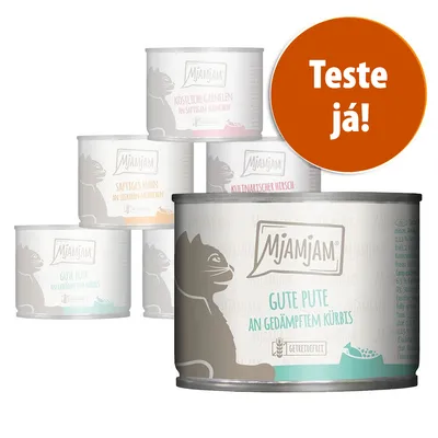 Várias latas de comida para gatos MjAMjAM com diferentes sabores visíveis em alemão. Selo laranja com texto: 'Teste já!'.