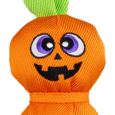 Giocattolo di stoffa a forma di zucca con volto ricamato e foglie verdi, materiale arancione, cuciture visibili.