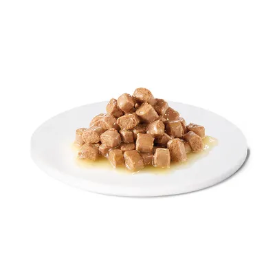 Närbild av bruna köttbitar i sås, serverade på en vit tallrik.