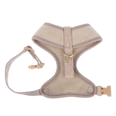 Harnais pour animal en tissu beige, maille respirante visible, boucle de fermeture plastique et anneau métallique doré sur le dessus. Aucun texte ou marque visible.