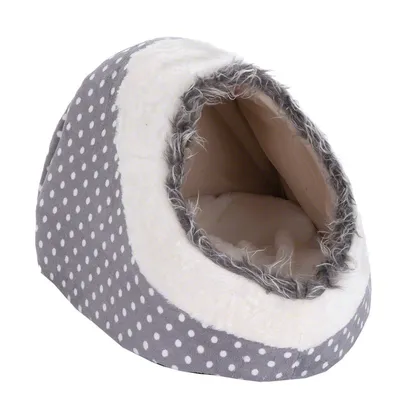 Niche en tissu gris à pois blancs, forme igloo, entrée bordée de fausse fourrure grise et blanche, intérieur rembourré beige visible.