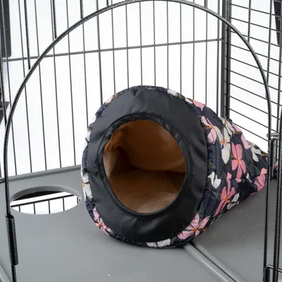 Musta kukkakuosinen pehmotunneli, jossa pehmeä sisävuori, sijoitettu metallihäkkiin.