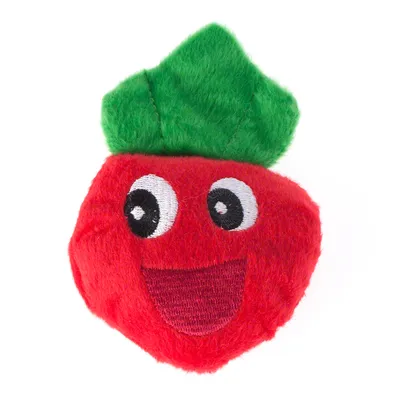 Jouet en peluche rouge en forme de fruit avec visage souriant brodé et feuilles vertes, matière textile visible.