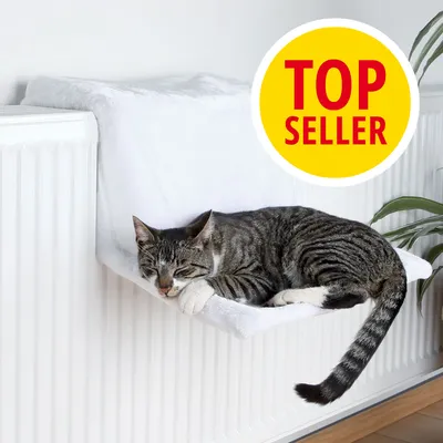 Szary kot leży na białym legowisku zawieszonym na kaloryferze; widoczny żółty okrąg z napisem TOP SELLER.
