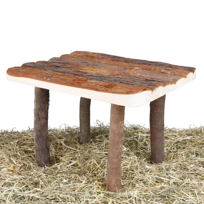 Wooden platform with natural bark and four wooden legs, standing on hay.