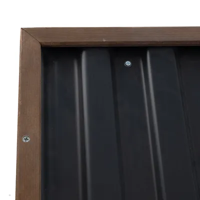 Detailní pohled na černý kovový plech s dřevěným rámem a viditelnými šrouby.
