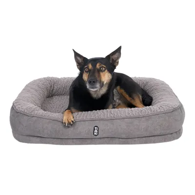 Szare legowisko Tiaki dla psa z miękkim brzegiem i wyściełaną powierzchnią do leżenia. Pies leży w legowisku.