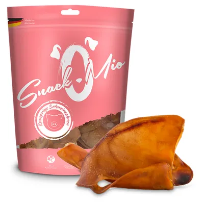 Snack-Mio, sachet rose avec texte allemand 'Knusprige Schweineohren', oreille de porc séchée visible devant l’emballage. Fabriqué en Allemagne indiqué en haut à gauche.