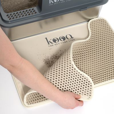 kooa Katzenstreumatte mit Wabenstruktur, zeigt Hand beim Anheben der Matte zur Reinigung. Logo 'kooa The Pet Care Line' sichtbar.