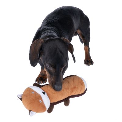 Cane che gioca con un gioco di peluche marrone a forma di volpe.
