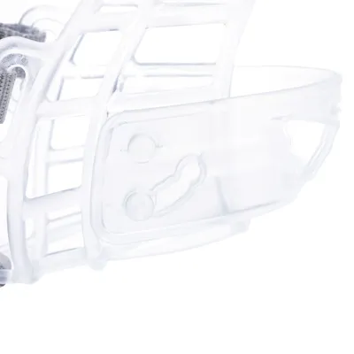 Muselière en plastique transparent avec lanière textile grise visible sur le côté gauche de l’image.