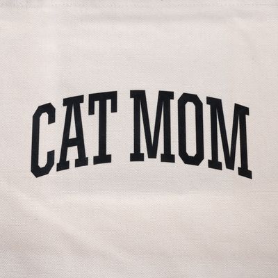 Lettering 'CAT MOM' in black capital letters on white fabric.