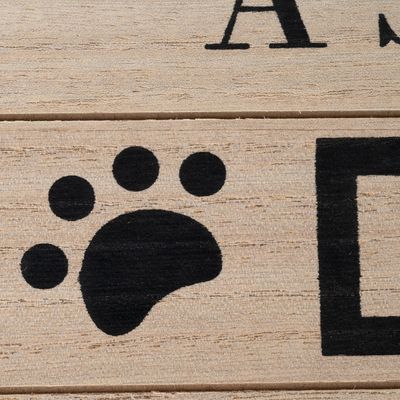 Superficie in legno con impronta di zampa nera e testo parzialmente visibile.