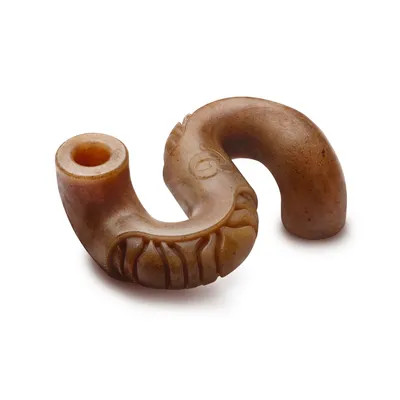 Jouet pour chien en forme de tube courbé, aspect marron, surface lisse avec des rainures sculptées visibles sur une partie du jouet. Aucun texte ou marque visible.
