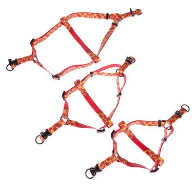 Drei rote Hundegeschirre mit gelbem Muster und schwarzen Schnallen, verstellbar mit Metallringen.