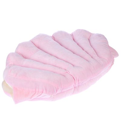 Alfombrilla acolchada rosa en forma de concha, adecuada como superficie para tumbarse o cojín.