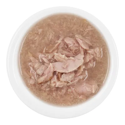 Close-up of shredded meat in broth, served in a white bowl.