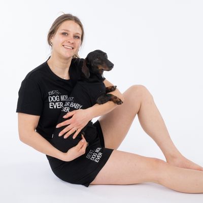 Person hält einen kleinen Hund, beide tragen schwarze Kleidung mit dem Text 'Best Dog Mom Ever' und 'Your Baby'.