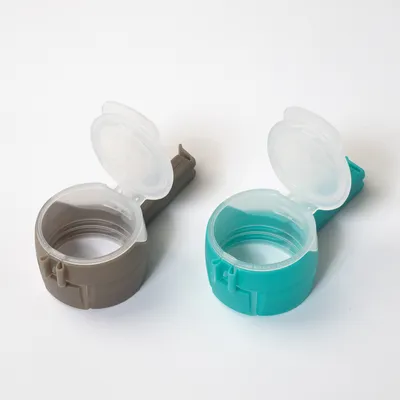 Two plastic lids in grey and turquoise with flip closure, suitable for sealing cans or containers.