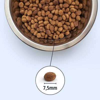 Cuenco de metal con croquetas marrones, vista detallada de una croqueta con indicación de tamaño: 7,5 mm de diámetro.
