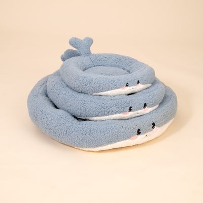 Drei blaue, runde Kuschelbetten aus Plüsch mit Wal-Gesicht und Schwanz, gestapelt in verschiedenen Größen.