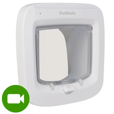 Białe drzwiczki dla zwierząt PetSafe z przezroczystą klapką, widoczne logo marki. W lewym dolnym rogu zielona ikona kamery wideo.
