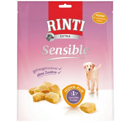 Balení Rinti Extra Sensible, viditelný text: gefriergetrocknet, ohne Zusätze, Huhn pur, nur 1+ tierisches Protein, Huhn für empfindliche Hunde. Kousky masa a pes na obalu.