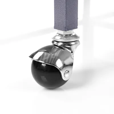 Nærbillede af en sort kuglerulle med sølvfarvet beslag, fastgjort til en violet metalramme.