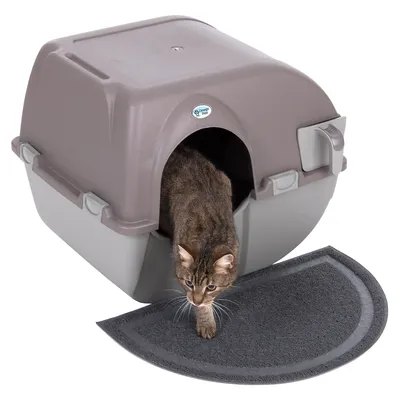 Katzentoilette mit Haube in Grau und Braun, Katze verlässt die Toilette. Halbkreisförmige Matte vor der Öffnung.