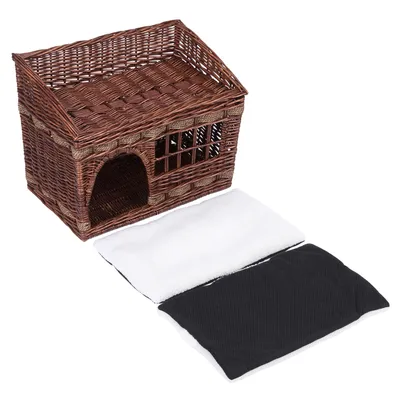 Cesto intrecciato marrone con tetto e ingresso, due cuscini rimovibili visibili in bianco e nero.