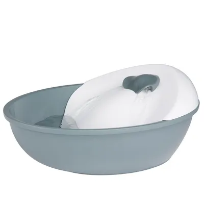 Drikkefontæne i grå og hvid plast med rindende vand, rund skålformet beholder. Ingen synlige mærker eller tekst.