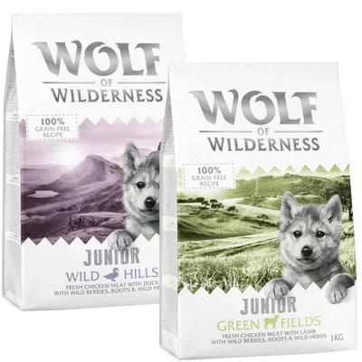 Wolf of Wilderness Junior hondenvoer, varianten Wild Hills en Green Fields, 100% grain-free recipe, met kip, eend of lam, wilde bessen, wortels en kruiden, verpakking van 1 kg zichtbaar.