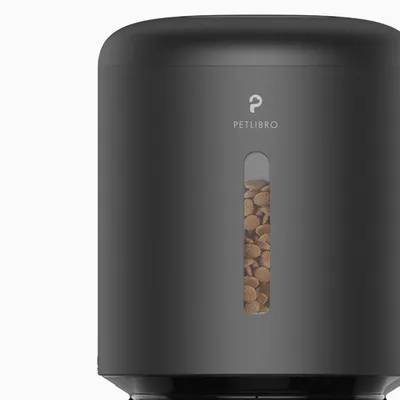 PETLIBRO black pet food dispenser with visible kibble inside through a clear window on the front. Brand name PETLIBRO shown above the window.