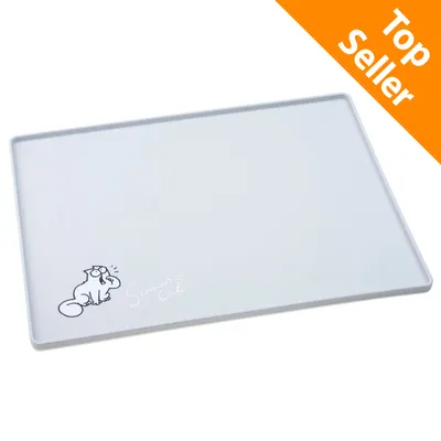 Tappetino bianco con bordo rialzato, angolo decorato con disegno di gatto e scritta 'Simon's Cat', materiale plastica. Etichetta arancione in alto a destra: Top Seller.