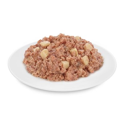 Zbliżenie mokrej karmy z kawałkami mięsa i kostkami ziemniaków na białym talerzu.