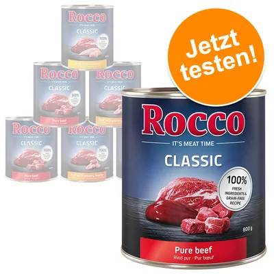 Rocco Classic Pure beef 800g tin, visible text: IT'S MEAT TIME, 100% fresh ingredients & grain-free recipe. Other Rocco Classic tins in background. Orange badge reads 'Jetzt testen!'. Rocco Classic Pure beef 800g tin, visible text: IT'S MEAT TIME, 100% fresh ingredients & grain-free recipe. Other Rocco Classic tins in background. Orange badge reads 'Jetzt testen!'.