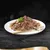 Sugestão de apresentação: pedaços de carne em molho num prato branco com garfo dourado, decorado com salsa.