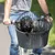 Cestino anteriore in plastica intrecciata con griglia di sicurezza in metallo, montato su bicicletta, cane di piccola taglia all’interno.