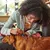Person using a blue grooming comb to brush the fur of a brown dog, demonstrating how to use the grooming tool on a pet.