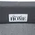 Grauer Stoff mit weissem Patch und schwarzer Aufschrift 'Home sweet HOME'.