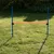 Hindernis-Set mit zwei blauen Stangen und einer verstellbaren roten Querlatte, geeignet für Training oder Agility im Garten.