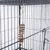 Jouet suspendu en bois et corde à l’intérieur d’une cage métallique pour oiseaux ou petits animaux, accroché par un crochet en métal.