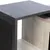 Detailansicht eines Möbelstücks mit Holzoptik und schwarzer Kratzfläche aus Textilmaterial.